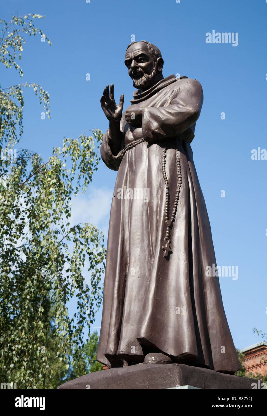 La statua di Pio da Pietrelcina aka Padre Pio con la Chiesa Cattolica Romana di San Otto dietro Slupsk Polonia Foto Stock