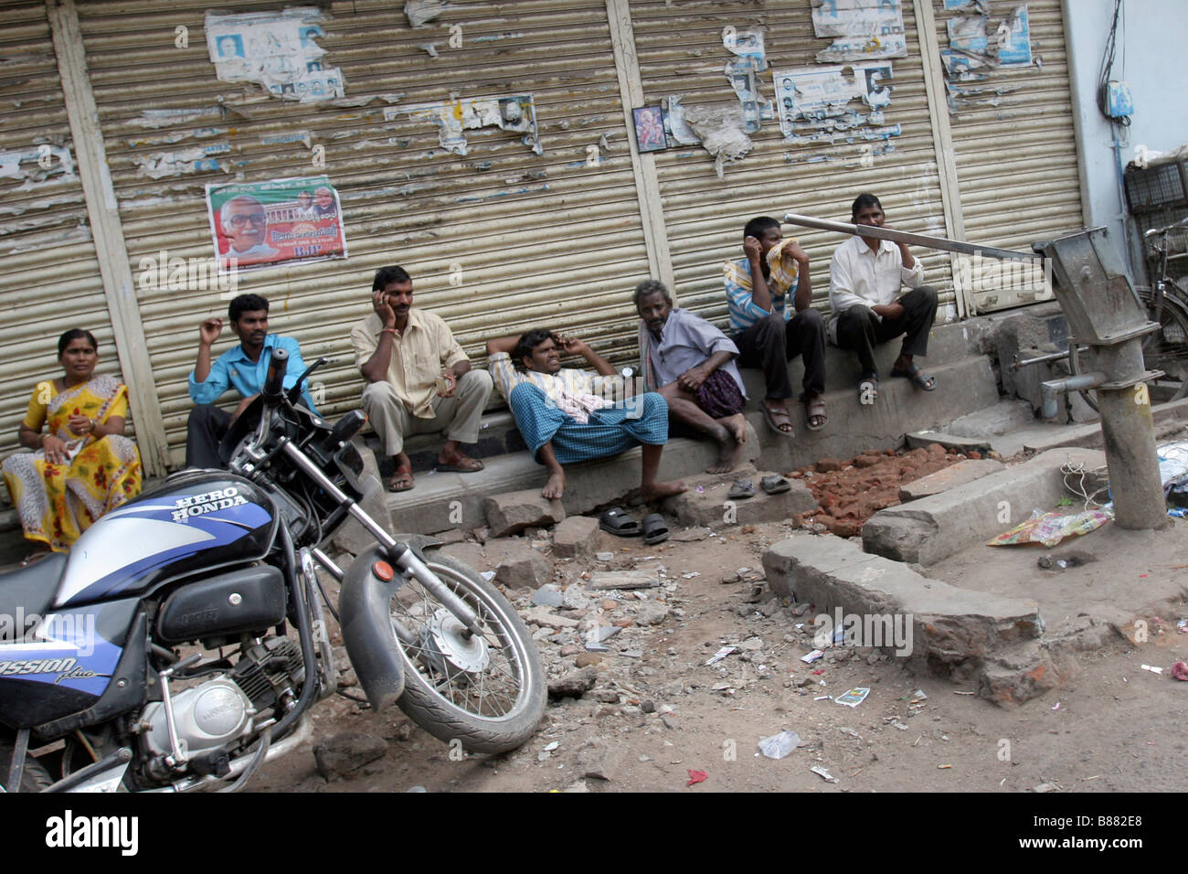 Persone sedersi sul lato della strada nella città di Hyderabad, in India. Foto Stock