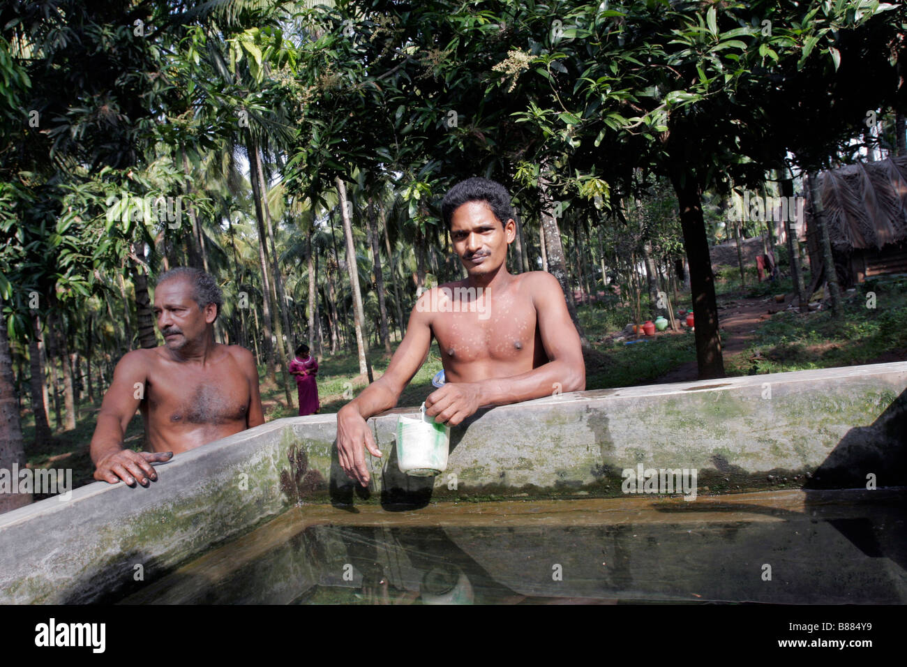Villaggi stare accanto a un serbatoio di inquinamento acqua non potabile in Plachimada in Kerala, in India. Foto Stock