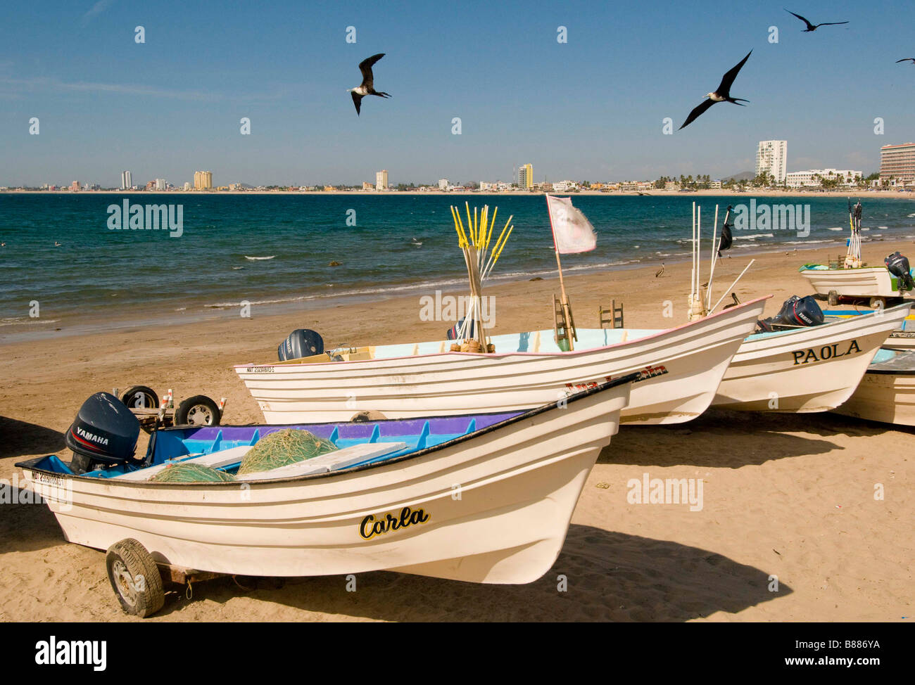 Messico SINOLA MEMBRO MAZATLAN vista panoramica di colorati di piccole barche da pesca e le fregate flying overhead. Olas Altas beach Foto Stock