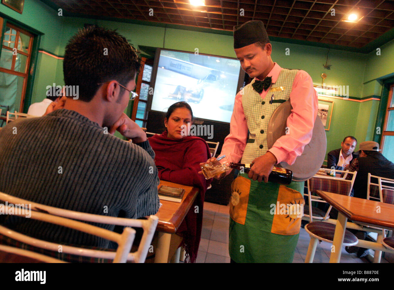 Un sordo cameriere serve clienti in un ristorante che impiega solo camerieri sordi a Kathmandu in Nepal Foto Stock