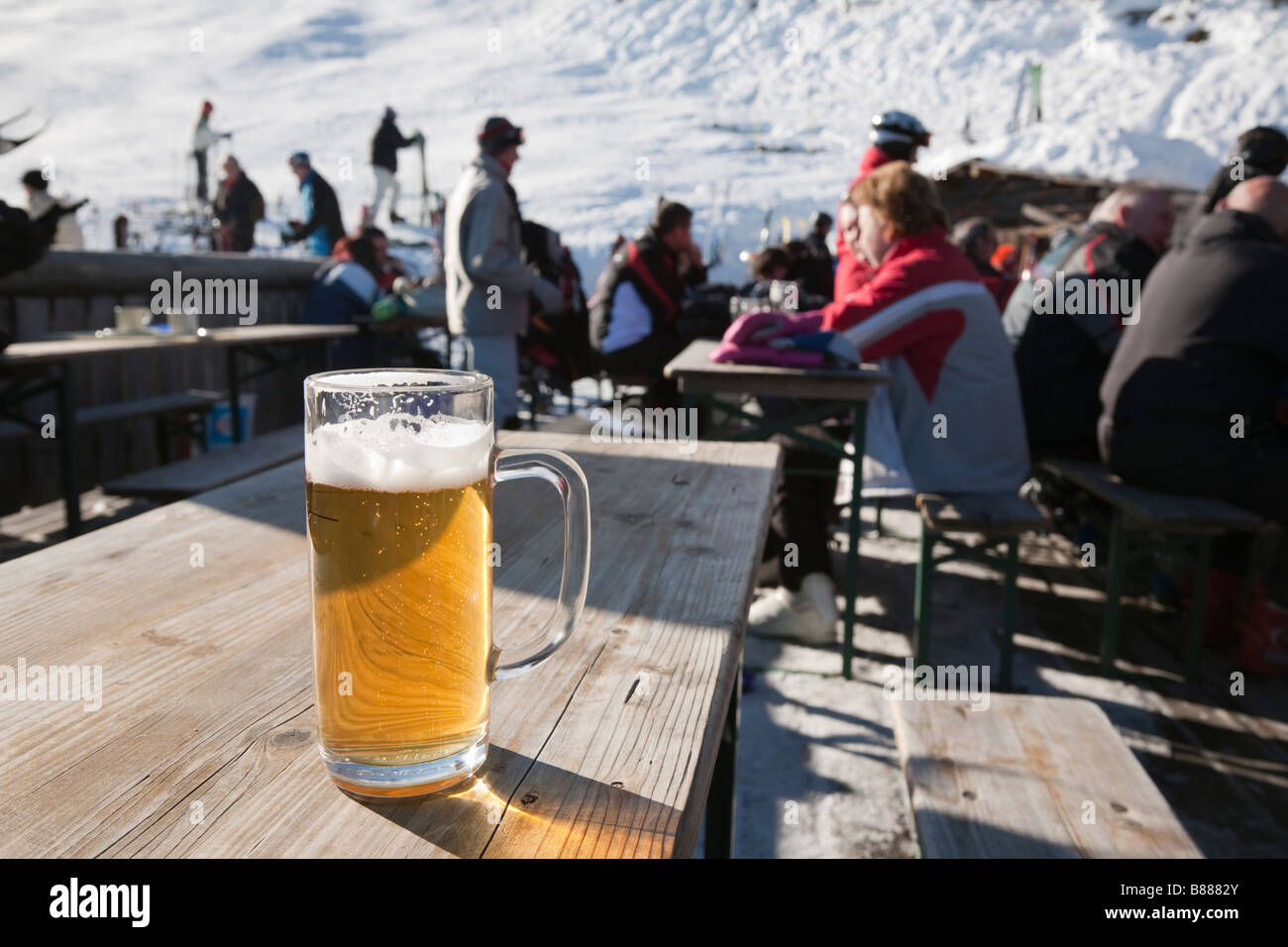 Bicchiere da birra sulla tavola in outdoor Bergrestaurant su piste innevate in località sciistica nelle Alpi austriache in inverno. Rauris Austria Europa Foto Stock