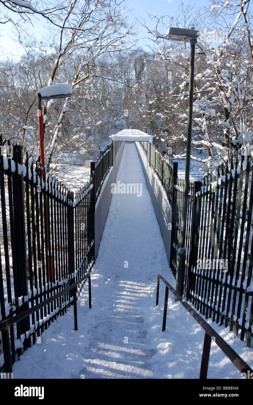 Le fasi che portano alla passerella sulla linea ferroviaria, tutto coperto di neve Foto Stock