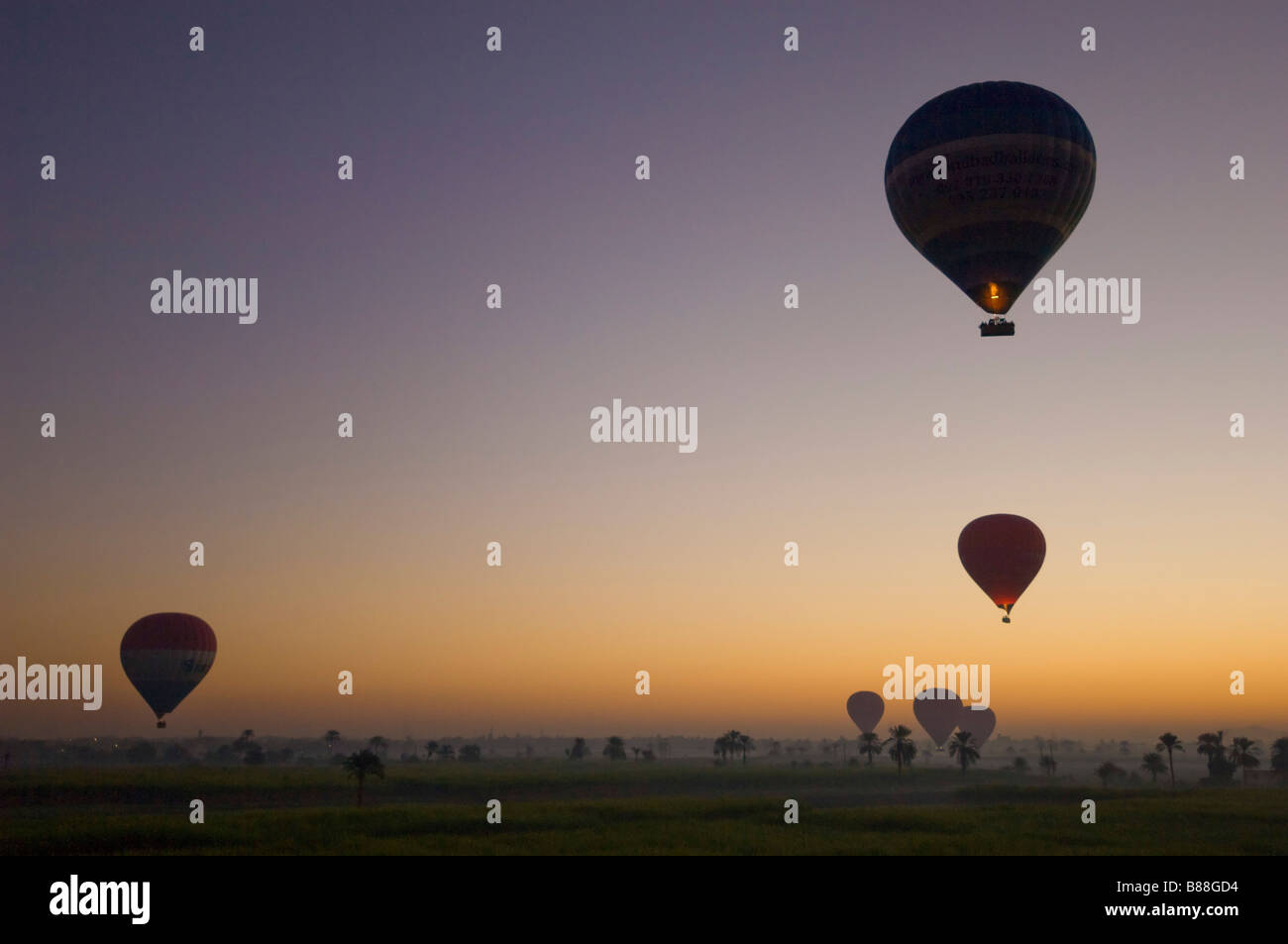 Un sacco di mongolfiere volare sopra il deserto di sunrise Egitto Medio Oriente Foto Stock