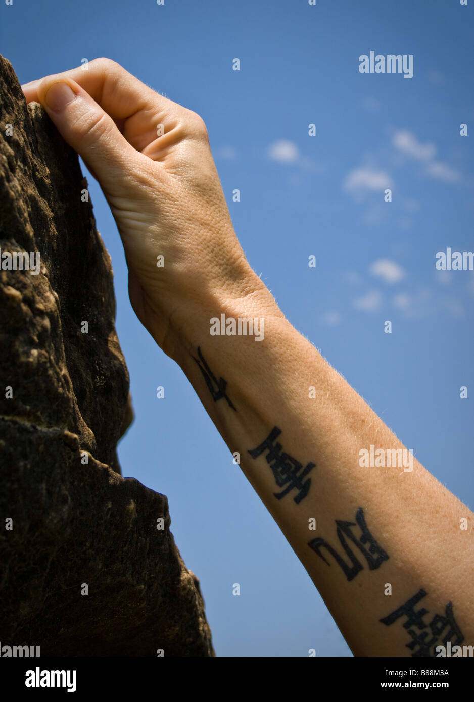 Canto femminile di scalatore che arrivano fino ad una messa in attesa su una parete di roccia. Foto Stock