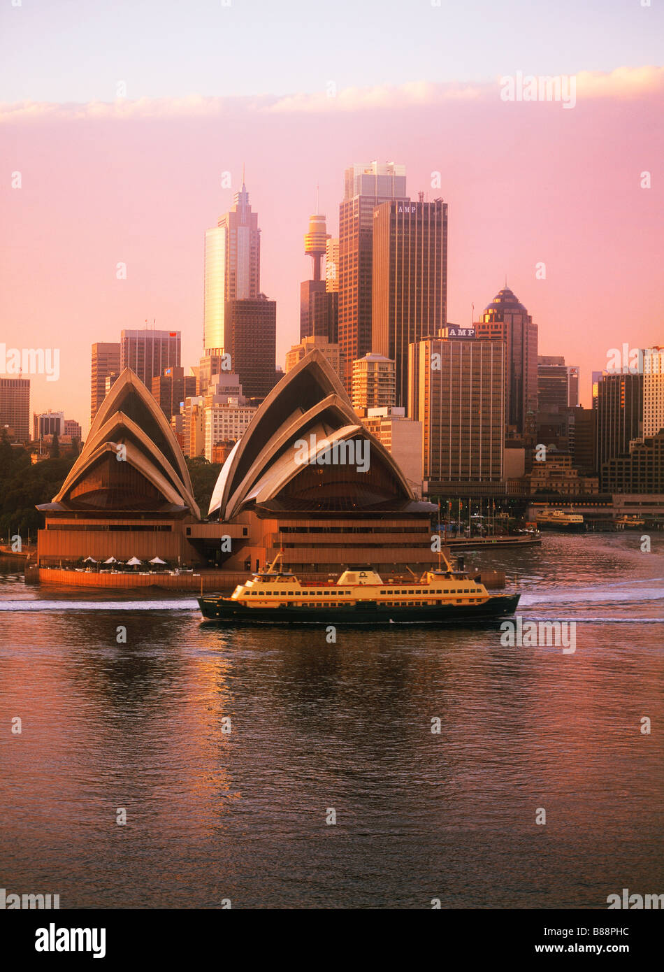 Car ferry boat con attraversamento passeggeri Porto di Sydney sotto la Opera House e dello skyline della città all'alba Foto Stock