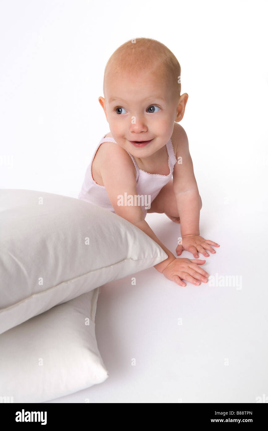 Il Toddler girlis nascondersi dietro un cuscino Foto Stock