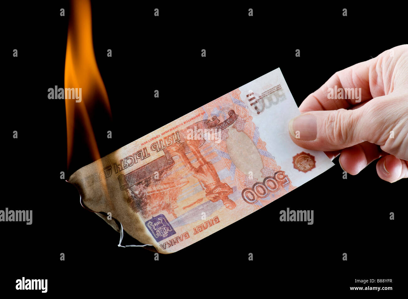Oggetto sul nero valuta bruciando denaro cartaceo Foto Stock