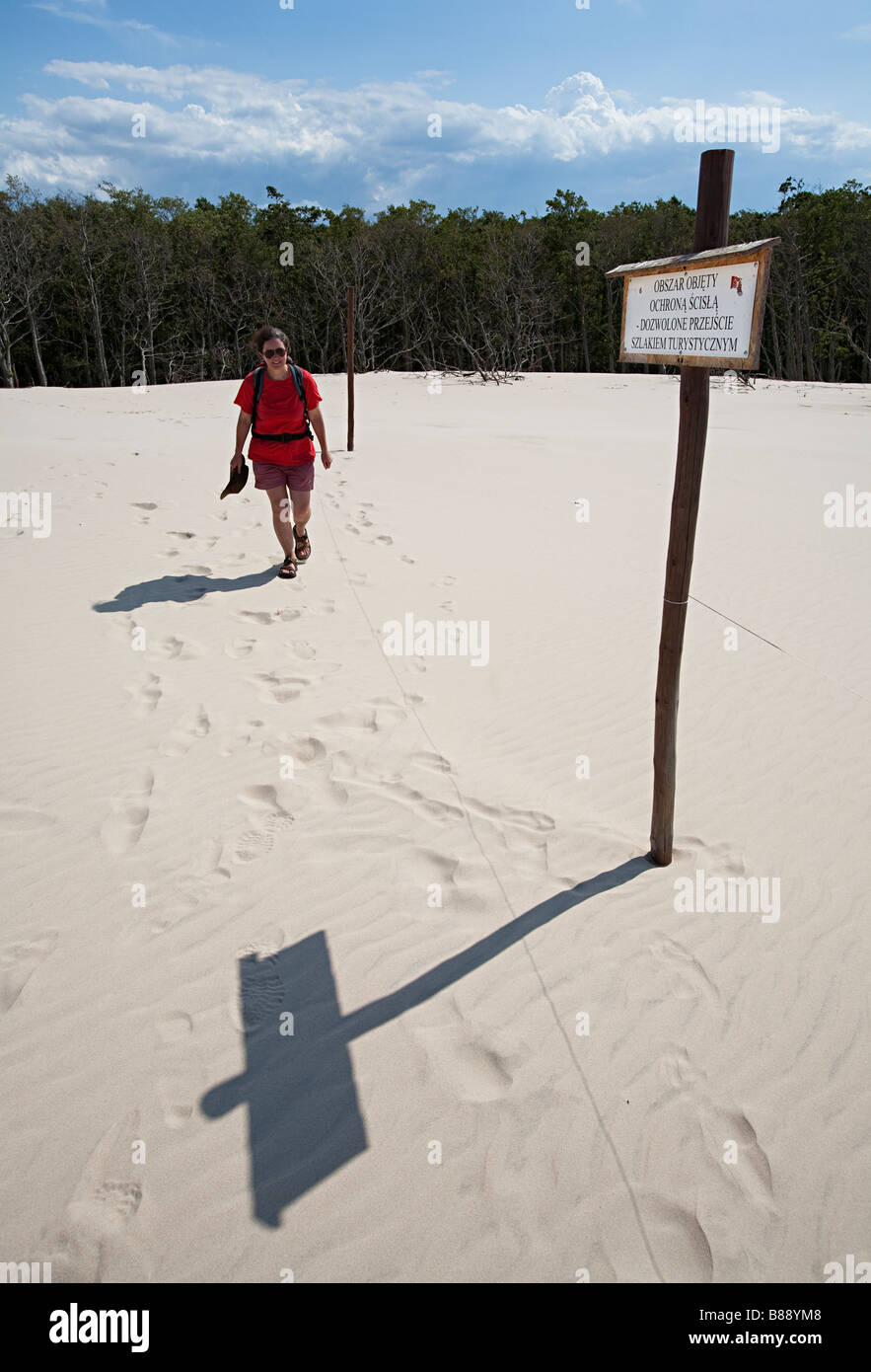 La donna a piedi passato segno in cordata fuori bordo della zona di conservazione di Lacka Gora dunes Parco Nazionale di Slowinski Leba Polonia Foto Stock