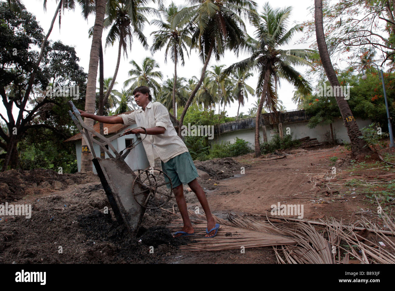 Un lavoratore discariche a sinistra su materiali provenienti da un impianto di trattamento delle acque in Panjim in Goa in India Foto Stock