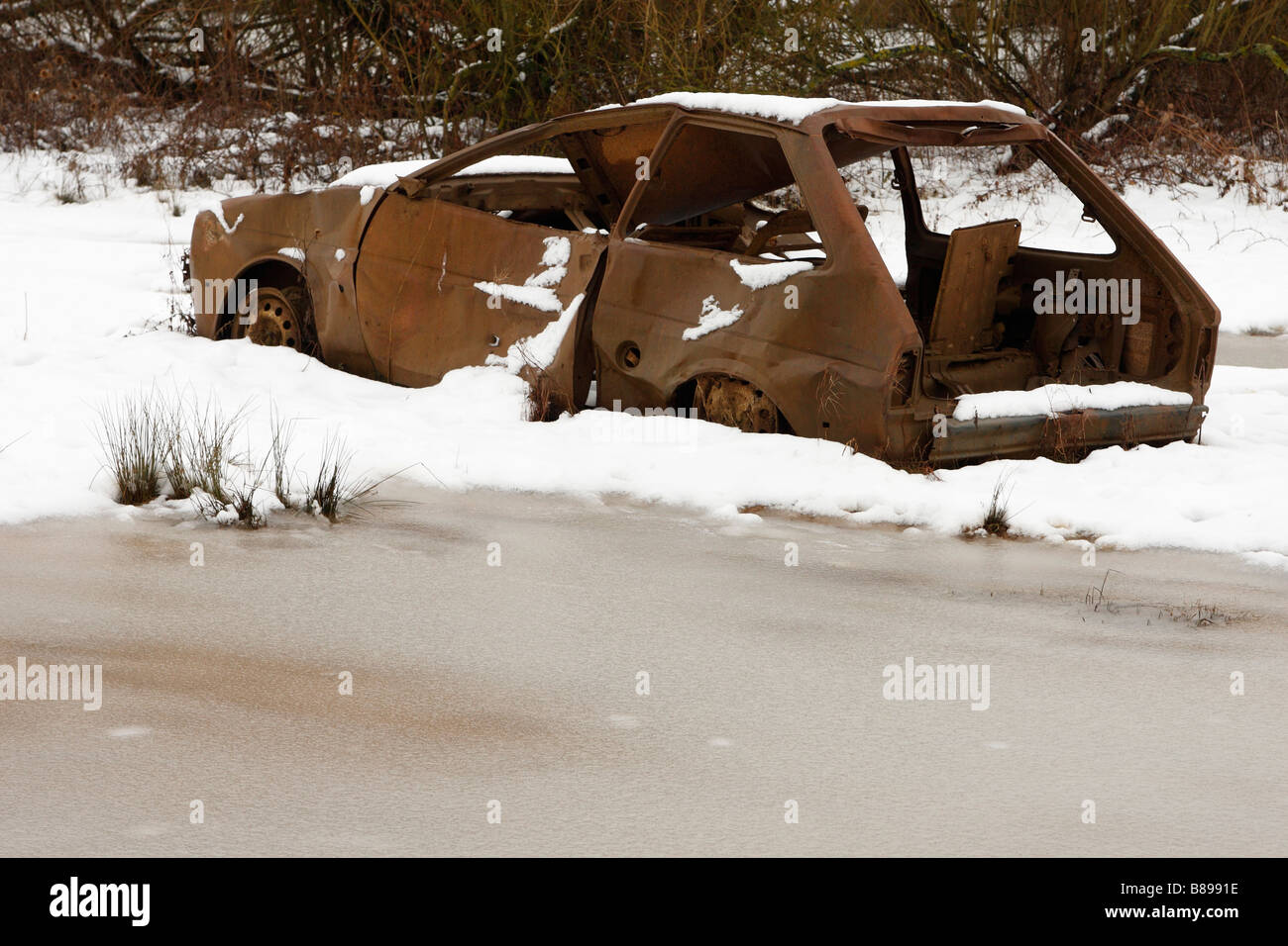 "Bruciato" auto abbandonate nella neve coperto campo, Inghilterra, Regno Unito, inverno Foto Stock