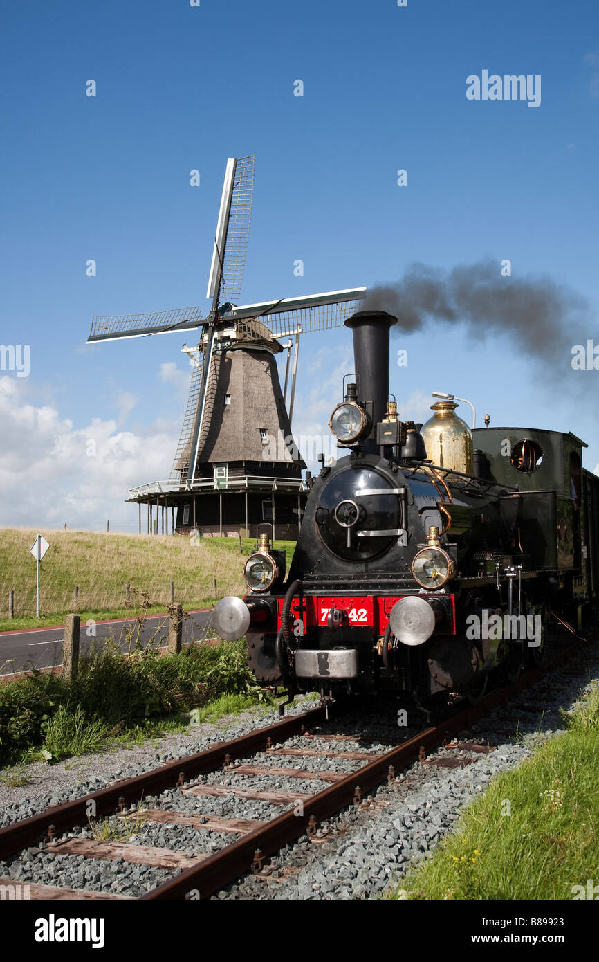 Treno a vapore sulla sezione turistica di via passando il mulino a vento a Enkhuizen Paesi Bassi Foto Stock