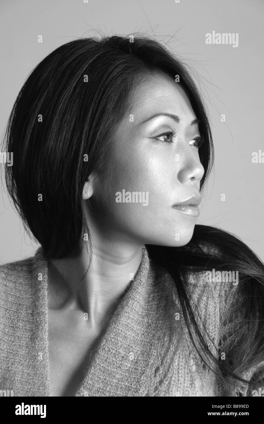 Bella donna asiatica guardando a lei lasciato in bianco e nero Foto Stock