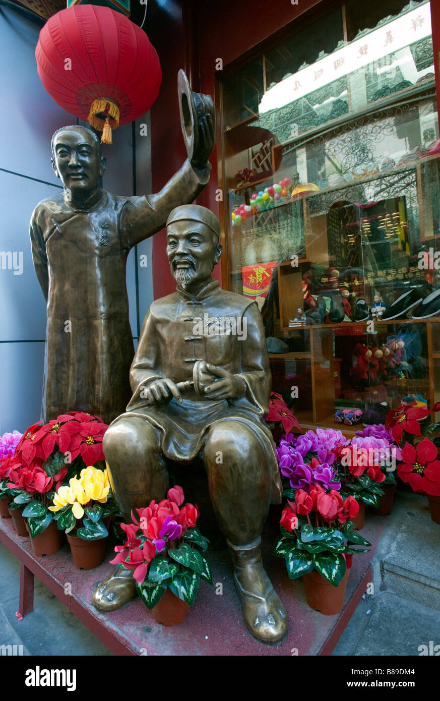 Statue in bronzo di due uomini in costume tradizionale al di fuori del famoso negozio di calzature in Qianmen centrale di Pechino 2009 Foto Stock