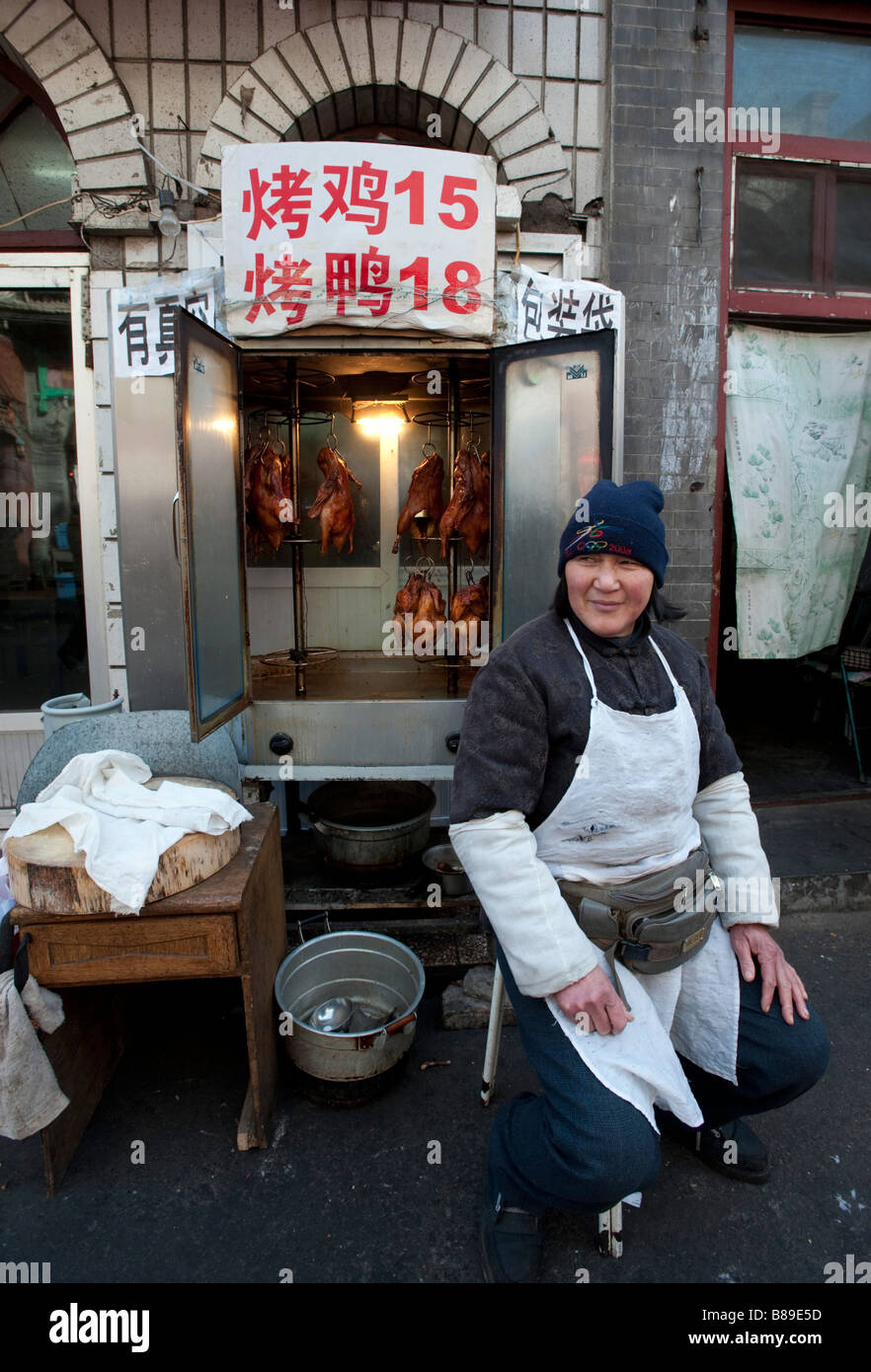 Donna street venditore a vendere polli arrosto e anatre di Pechino Cina 2009 Foto Stock
