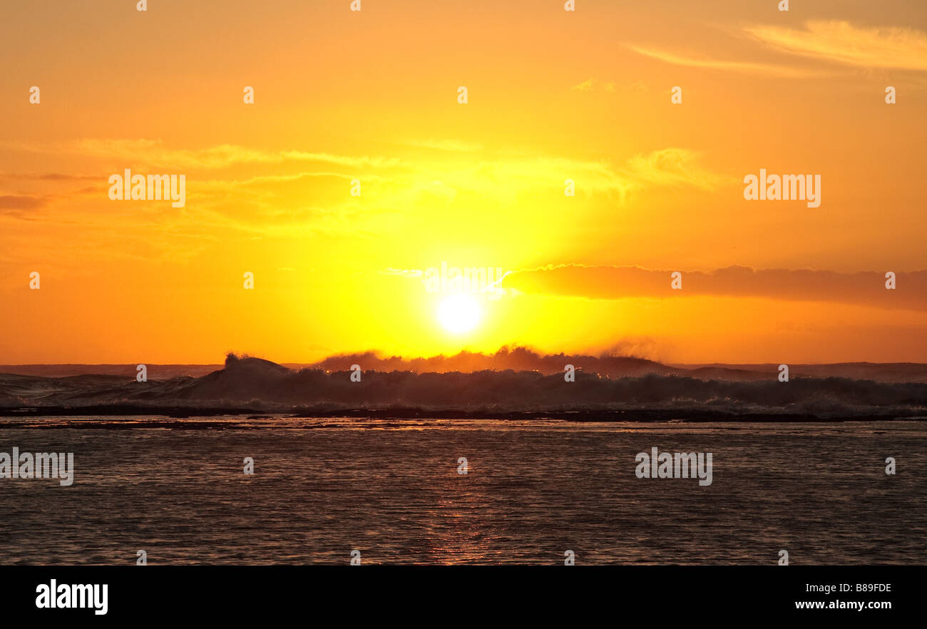 Sole che tramonta dietro il mare in tempesta Foto Stock