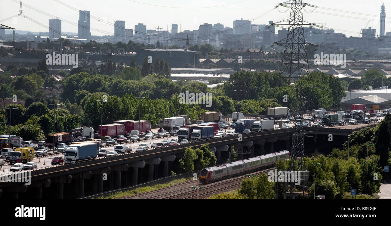 Il traffico pesante di pile fino sulla M6 vicino al Birmingham come passeggeri su un treno nelle vicinanze facilità passato senza alcun ritardo Foto Stock
