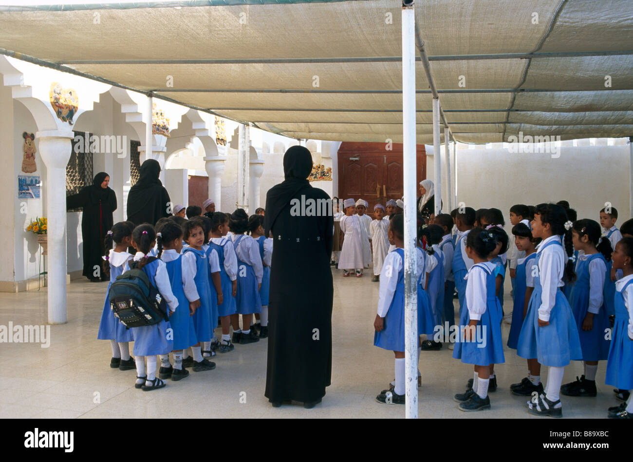 Sur Oman insegnanti di scuola primaria & Figli levarsi in piedi nelle linee Foto Stock