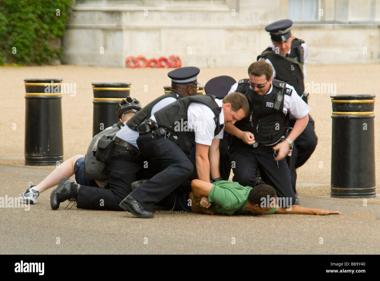 Chiudere orizzontale di un uomo sul pavimento resistente e di arresto essendo ammanettato da numerose forze di polizia nel centro di Londra. Foto Stock