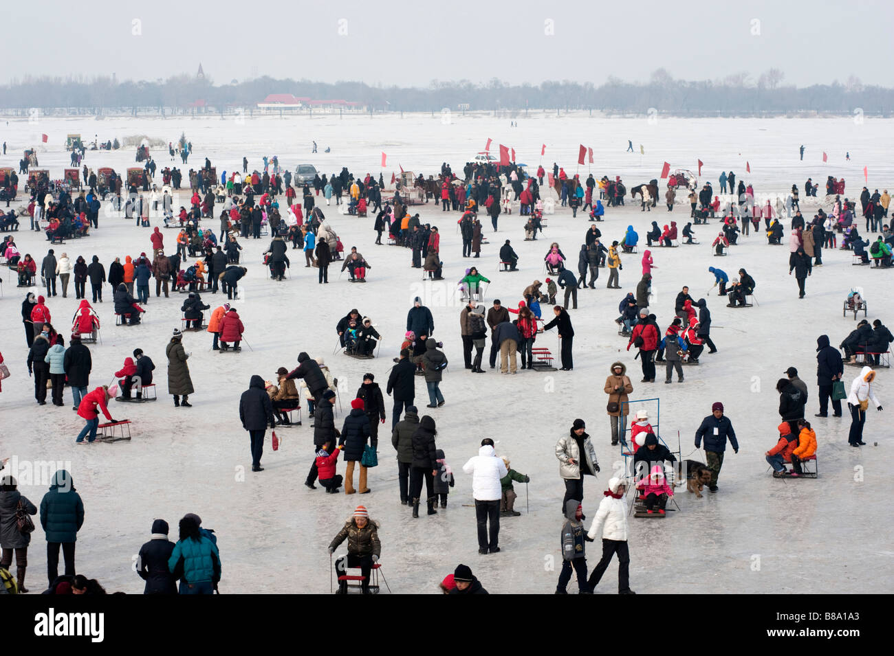 Molte persone pattinare su ghiaccio e slittino su pista di ghiaccio fatto sul fiume Songhua ghiacciato in inverno a Harbin Heilongjiang Cina Foto Stock