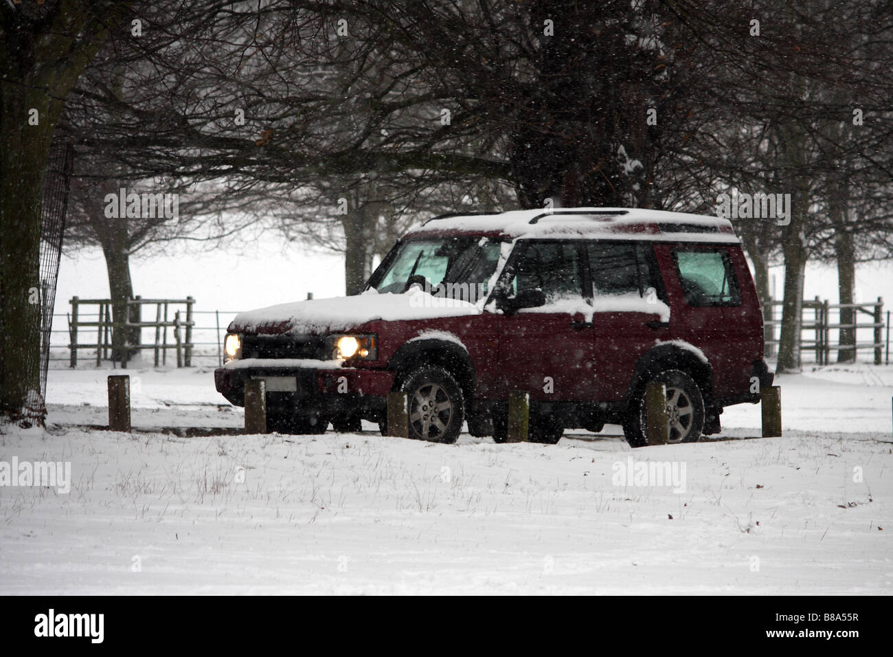 Un 4x4 Landrover Discovery guida attraverso le tempeste di neve in una fredda giornata di inverni Foto Stock