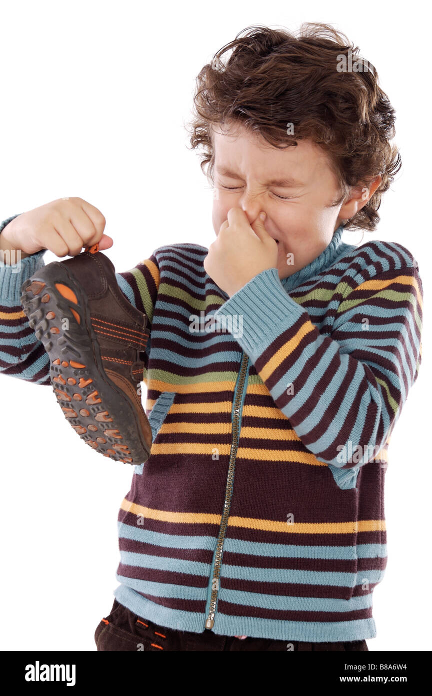 Carino giovane ragazzo con stinky calzatura pitching il suo naso Foto Stock