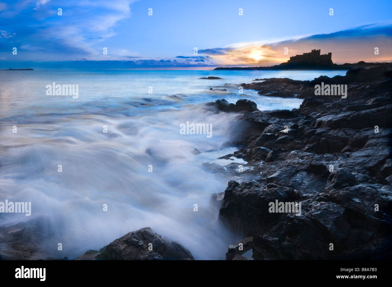 In inverno l'alba sopra il famoso castello di Bamburgh sulla costa nord est dell' Inghilterra Foto Stock