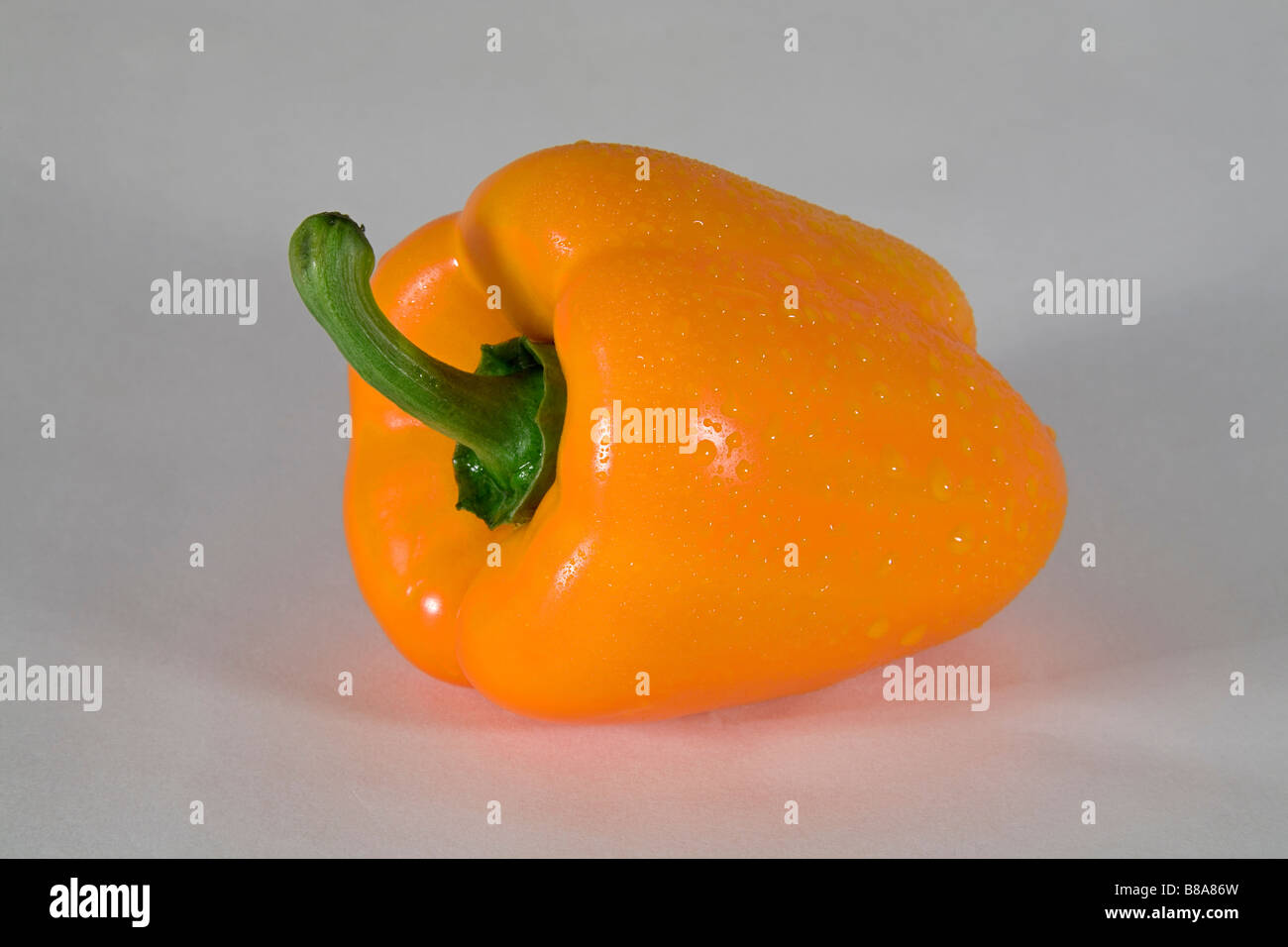 Un colore giallo o arancio il peperone tagliato a fette o intero. Foto Stock