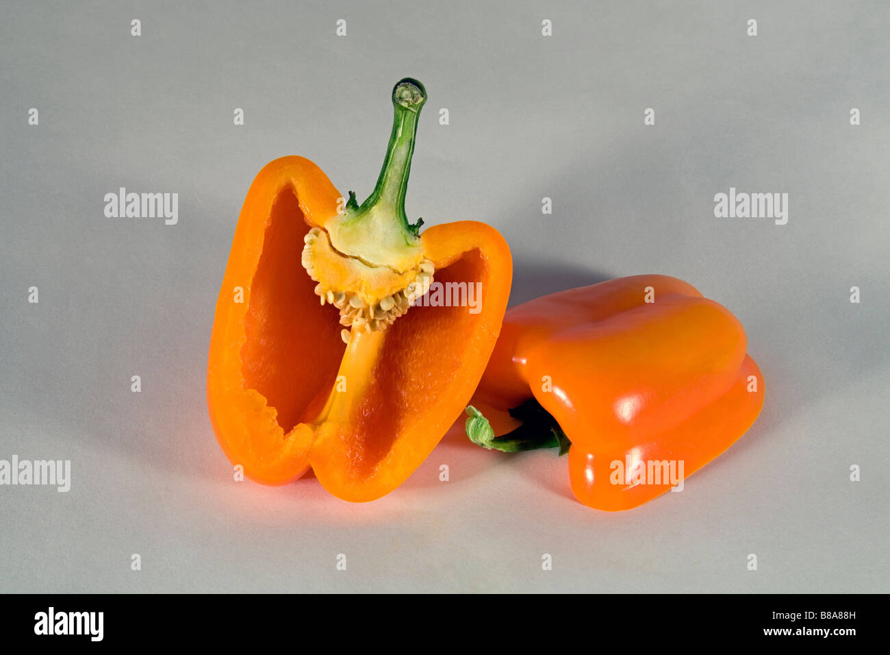 Un colore giallo o arancio il peperone tagliato a fette o intero. Foto Stock