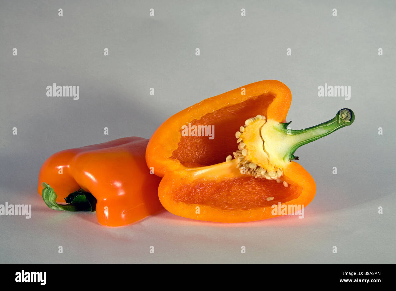 Un colore giallo o arancio il peperone tagliato a fette o intero. Foto Stock