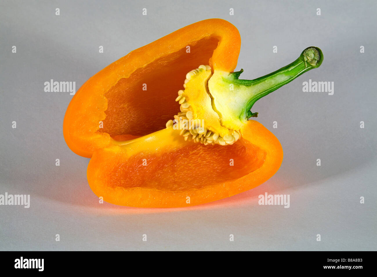Un colore giallo o arancio il peperone tagliato a fette o intero. Foto Stock