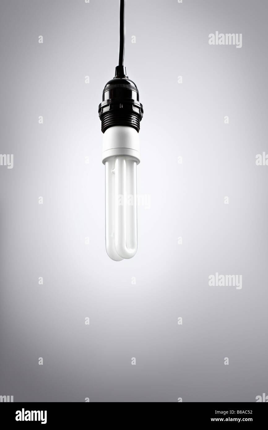 Vor Energiesparlampe hellgrauen Hintergrund Foto Stock