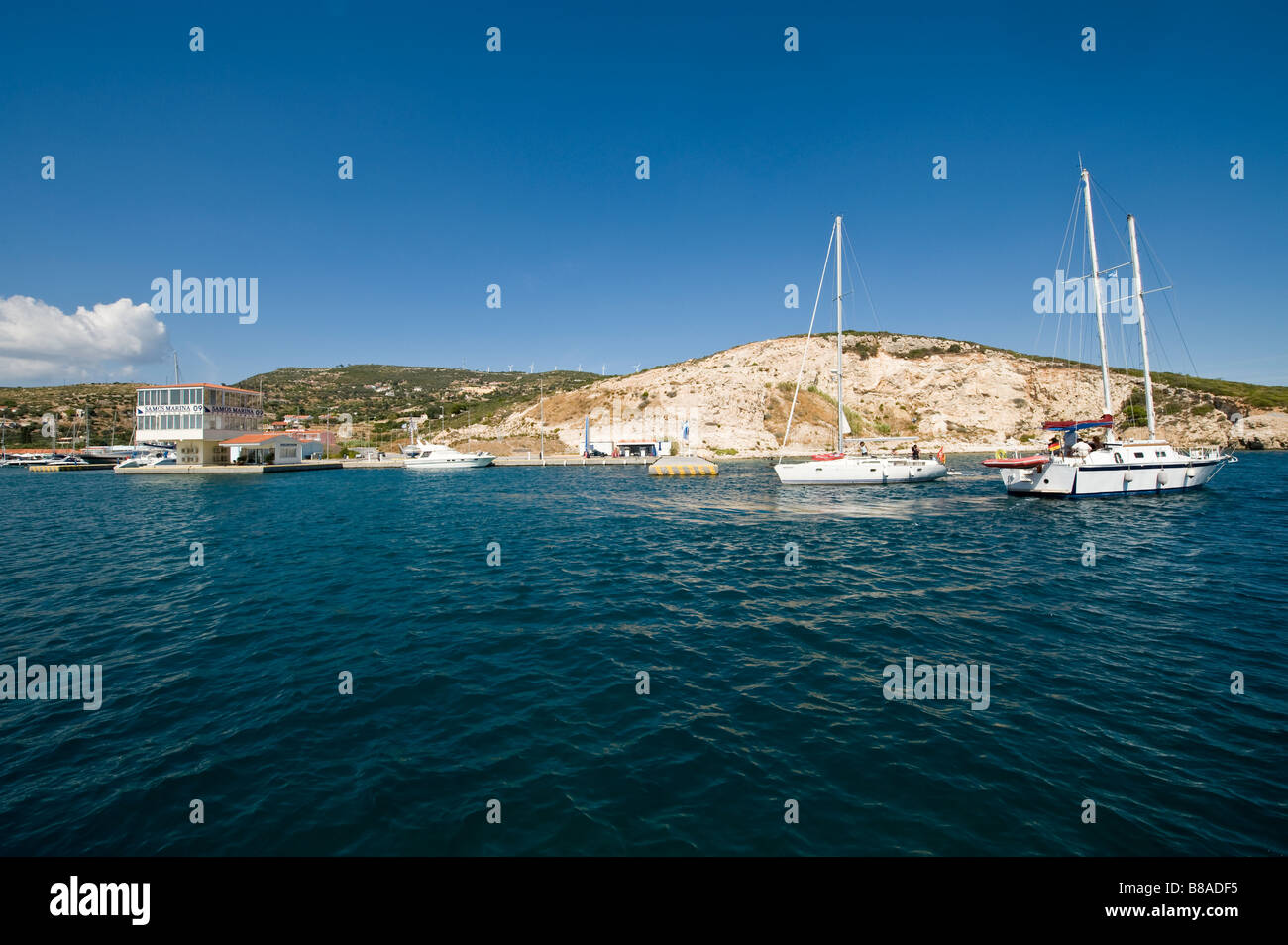 Barche lasciando una marina su un isola del mar Egeo Foto Stock