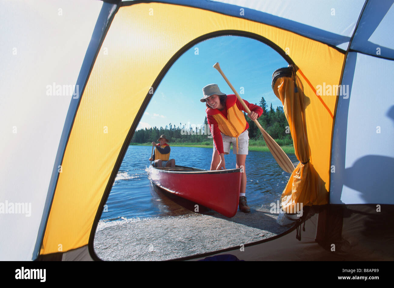 FV3302, Dave Reede; coppia di entrare in canoa, visto attraverso porta tenda, Whiteshell PP, Manitoba Foto Stock