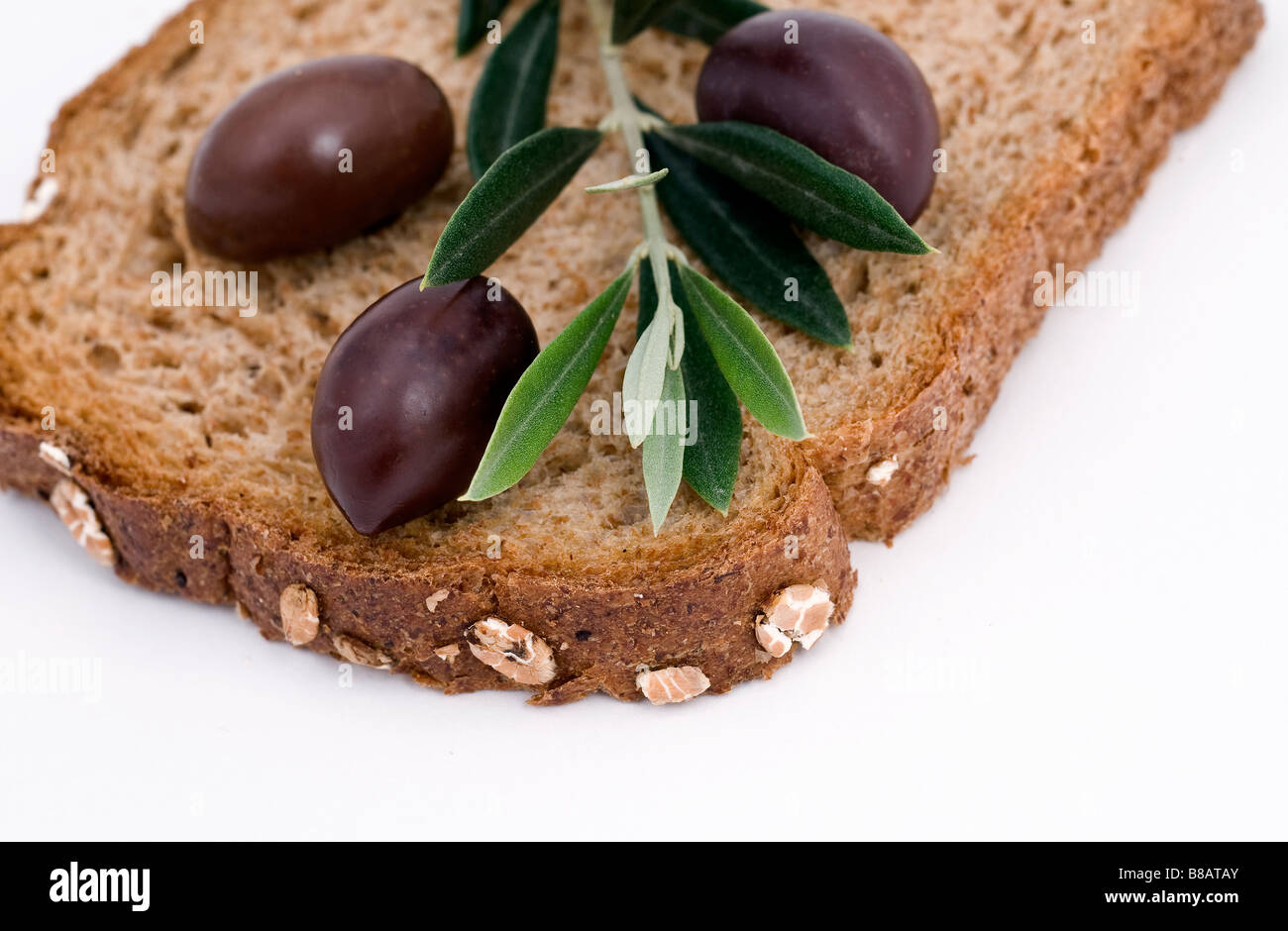Fetta di pane con i calli e le olive isolato su bianco Foto Stock