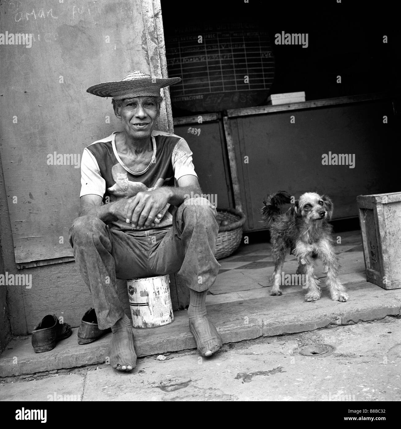 Uomo cubano seduta strada laterale a l'Avana, Cuba Foto Stock
