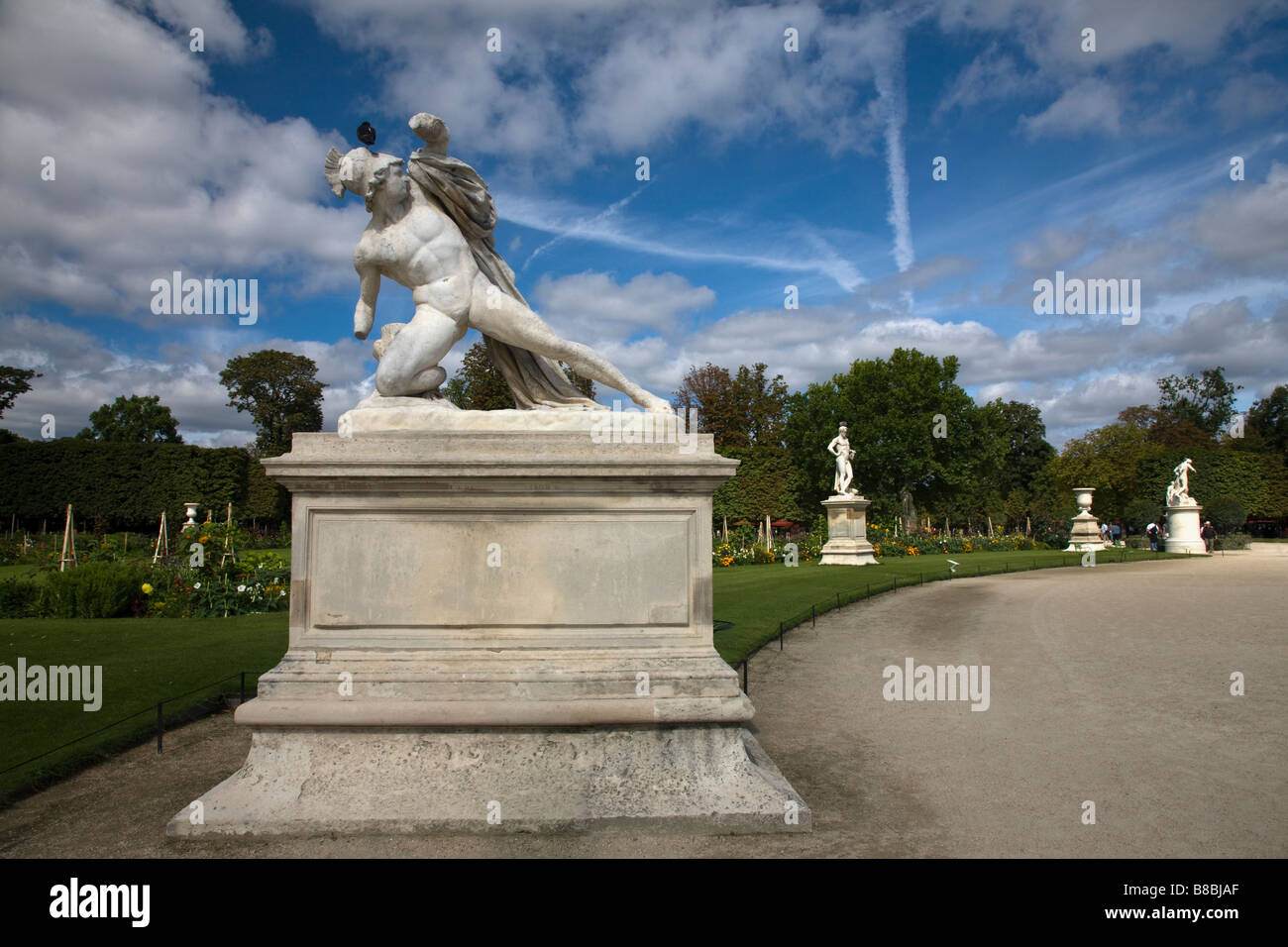 Drammatica cielo blu dietro le sculture Tuileries sculpture garden al di fuori del mondo famoso Louvre art museum Parigi Francia pigeon siede sulla testa della statua Foto Stock