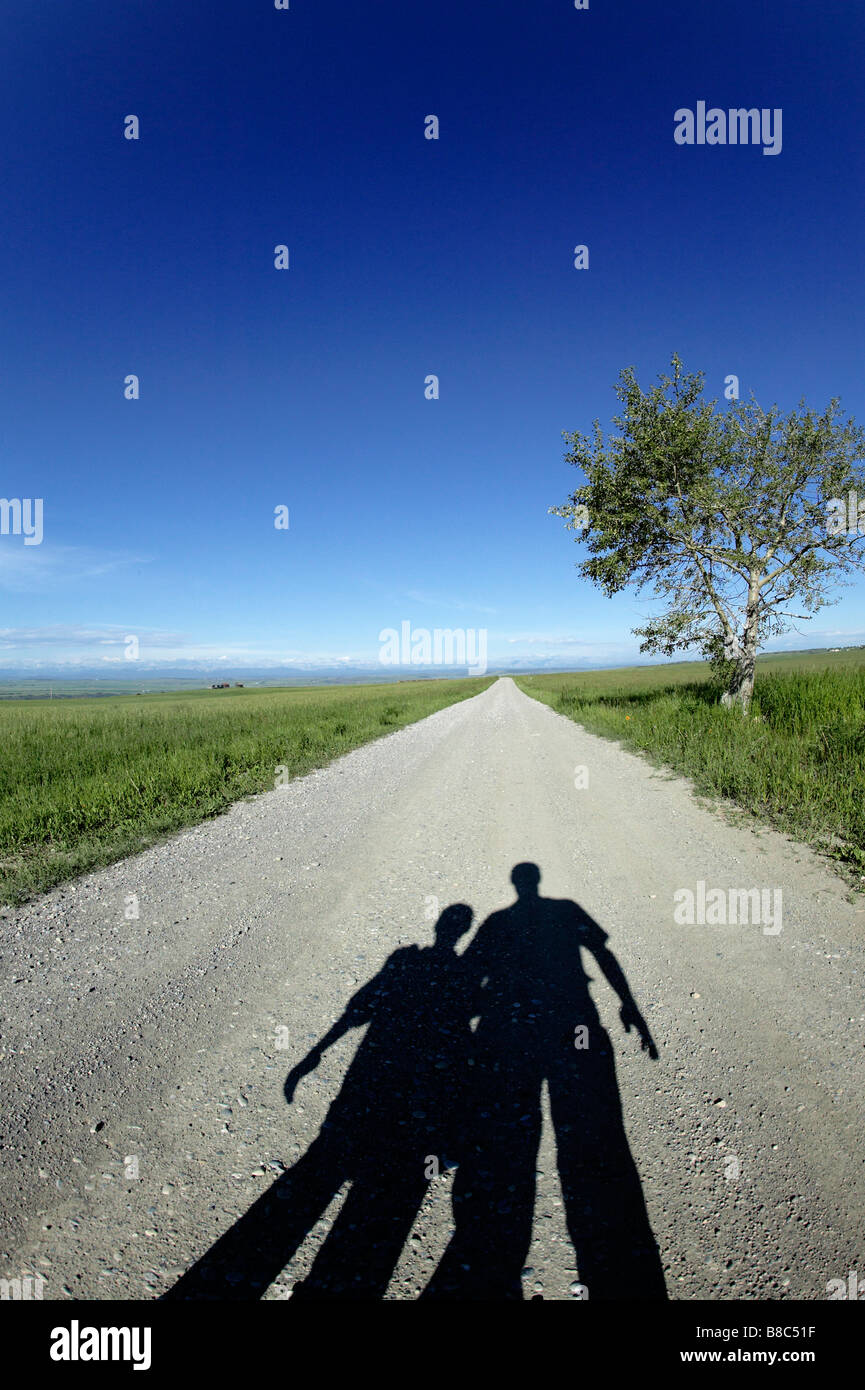 Ombra padre figlio lunga strada davanti, Calgary, Alberta Foto Stock