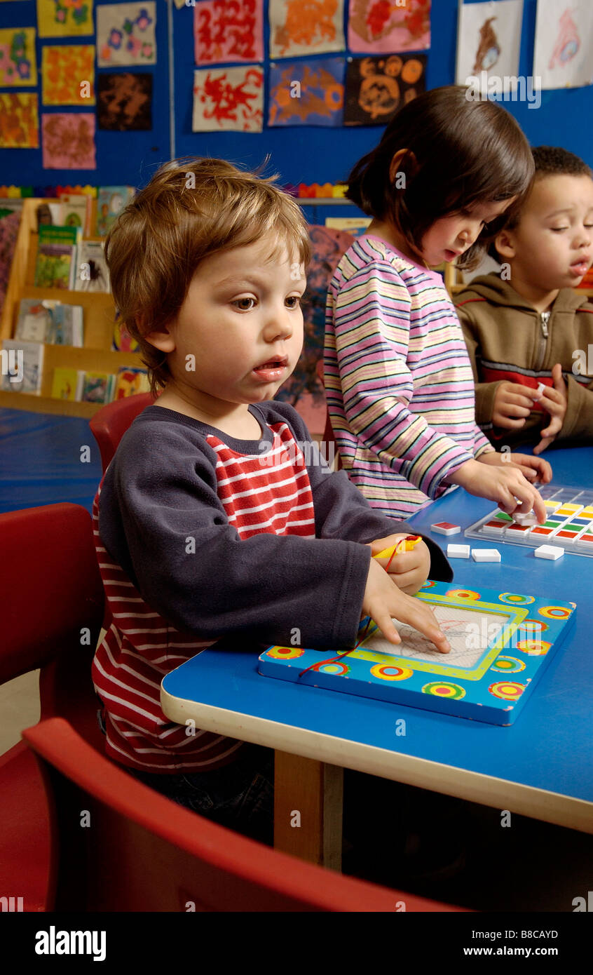 Quattro cinque anni di ragazzi che giocano a puzzle Classroom Foto Stock