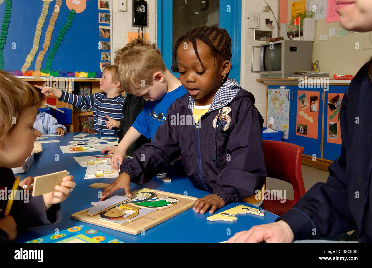Quattro cinque anni di ragazzi che giocano a puzzle Classroom Foto Stock
