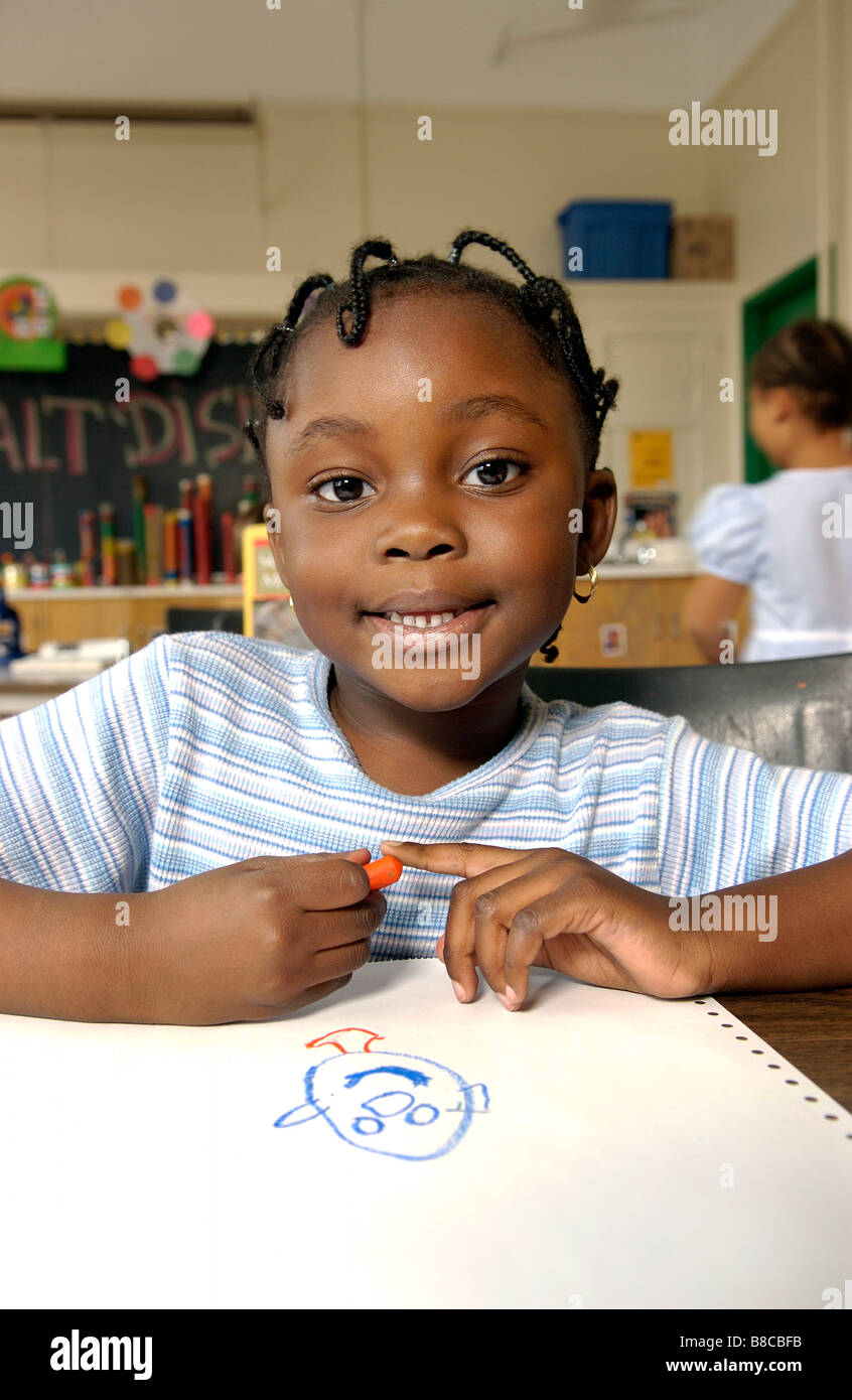 Bambina di cinque anni Disegno Aula Desk Foto Stock