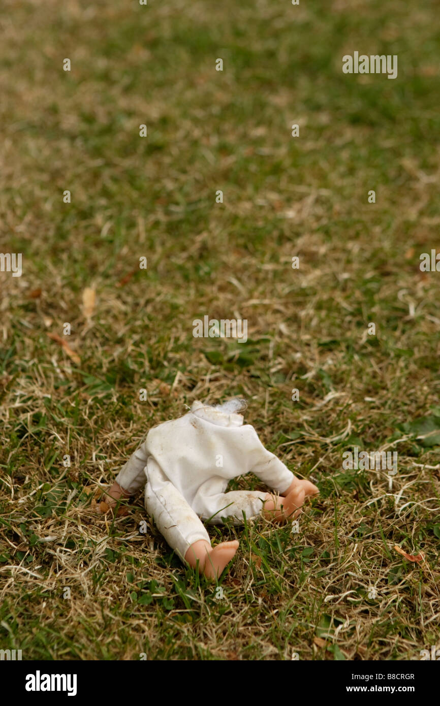 Una bambola mancante di una testa in un parco giochi. Foto Stock