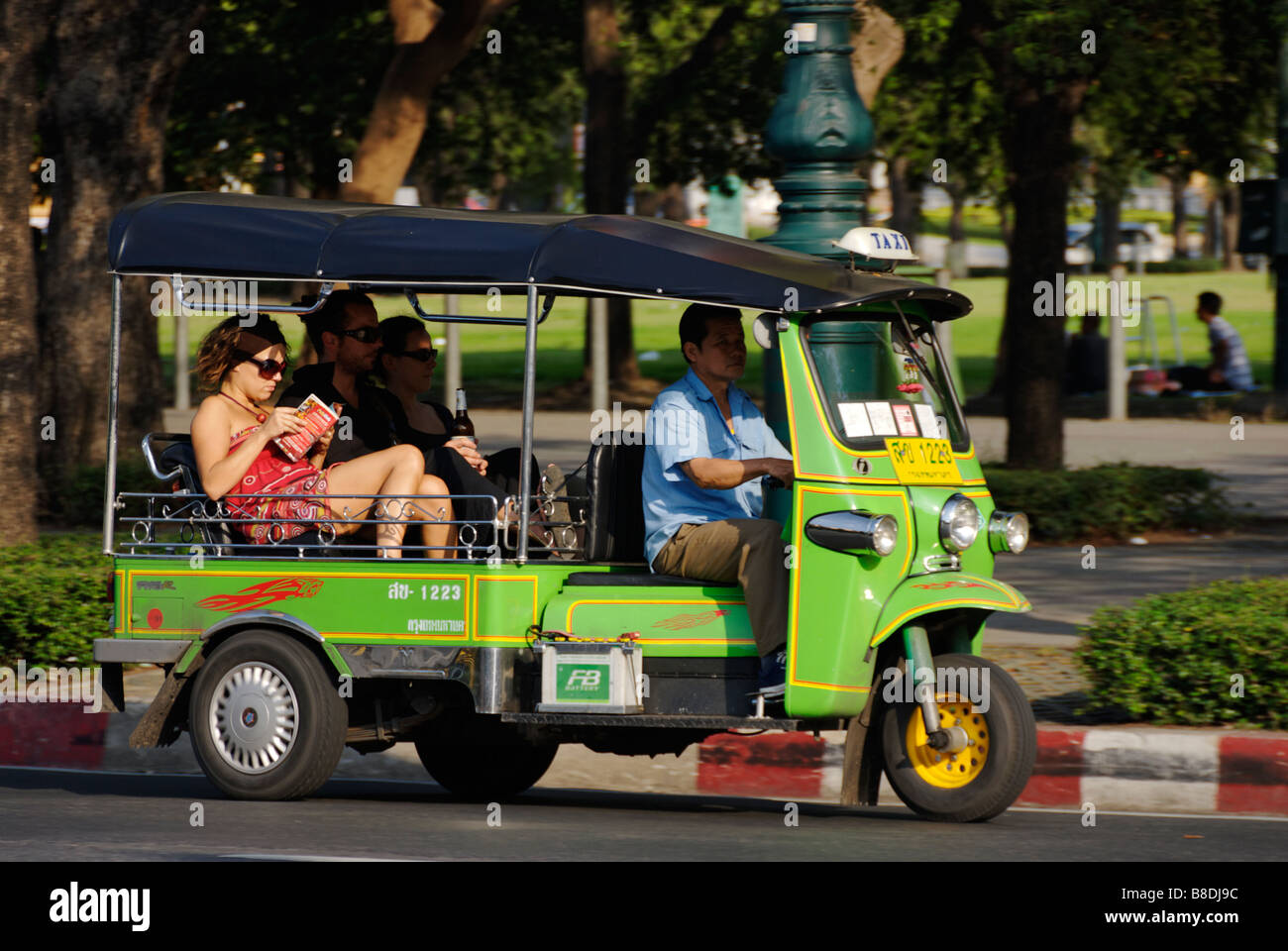 Turismo guida di lettura mentre in sella a un auto rickshaw nel quartiere di Banglamphu Bangkok in Thailandia Foto Stock