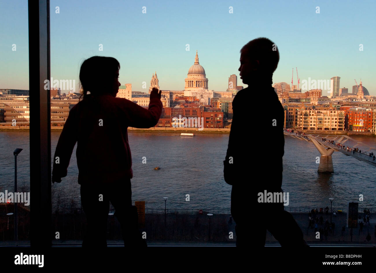 Mentre in piedi la Tate Modern Museum, due bambini guardano da una finestra all'orizzonte di Londra. Foto Stock