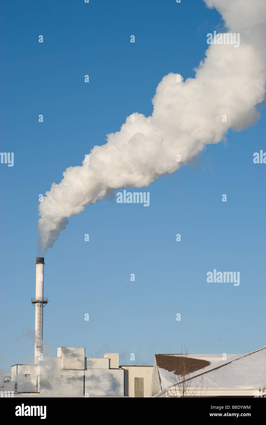 Le bocchette di ciminiere billowy vapore contro un freddo chiaro cielo blu Foto Stock