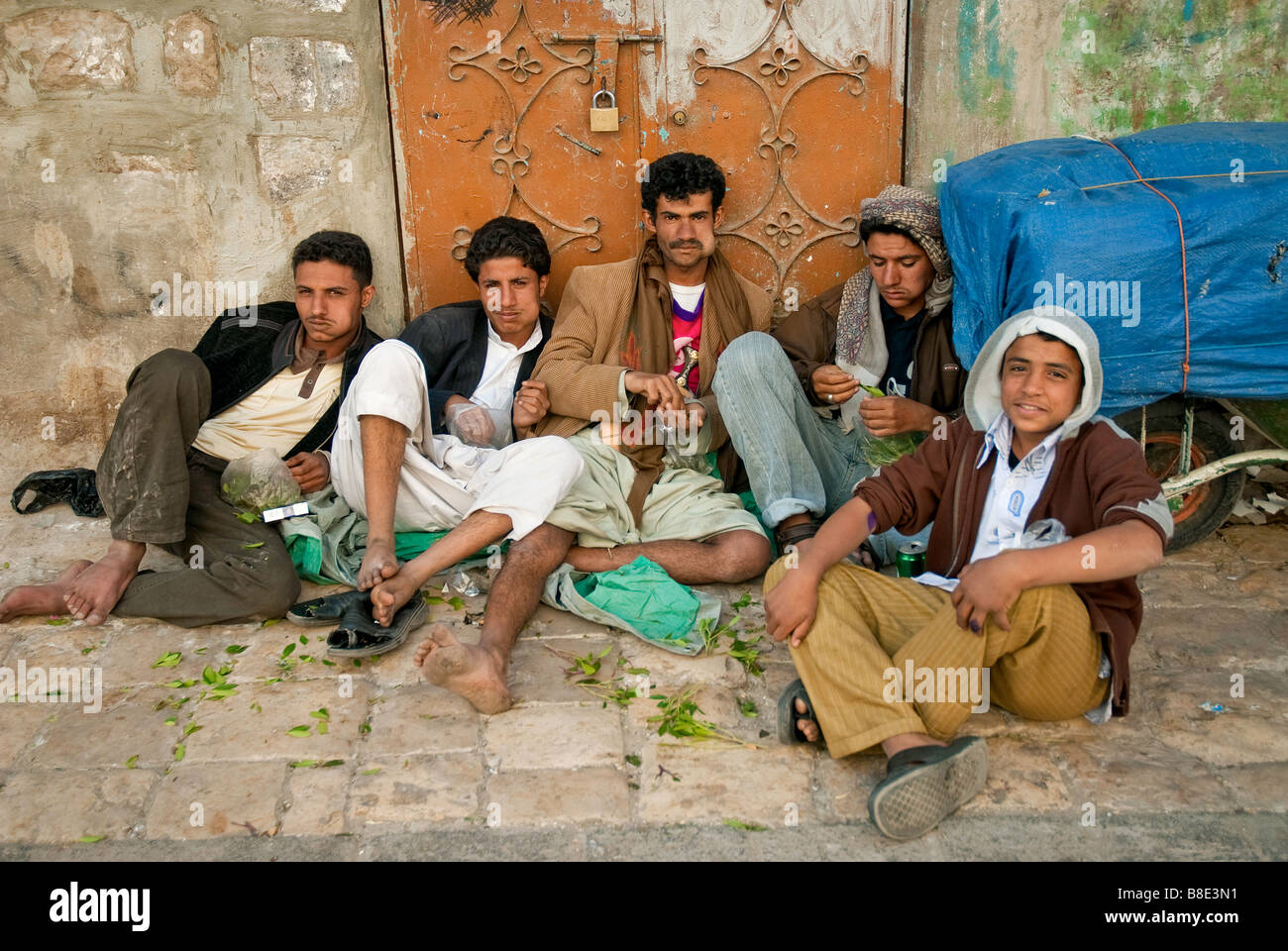 Uomini ragazzi di strada da masticare qat khat sanaa città yemen Foto Stock