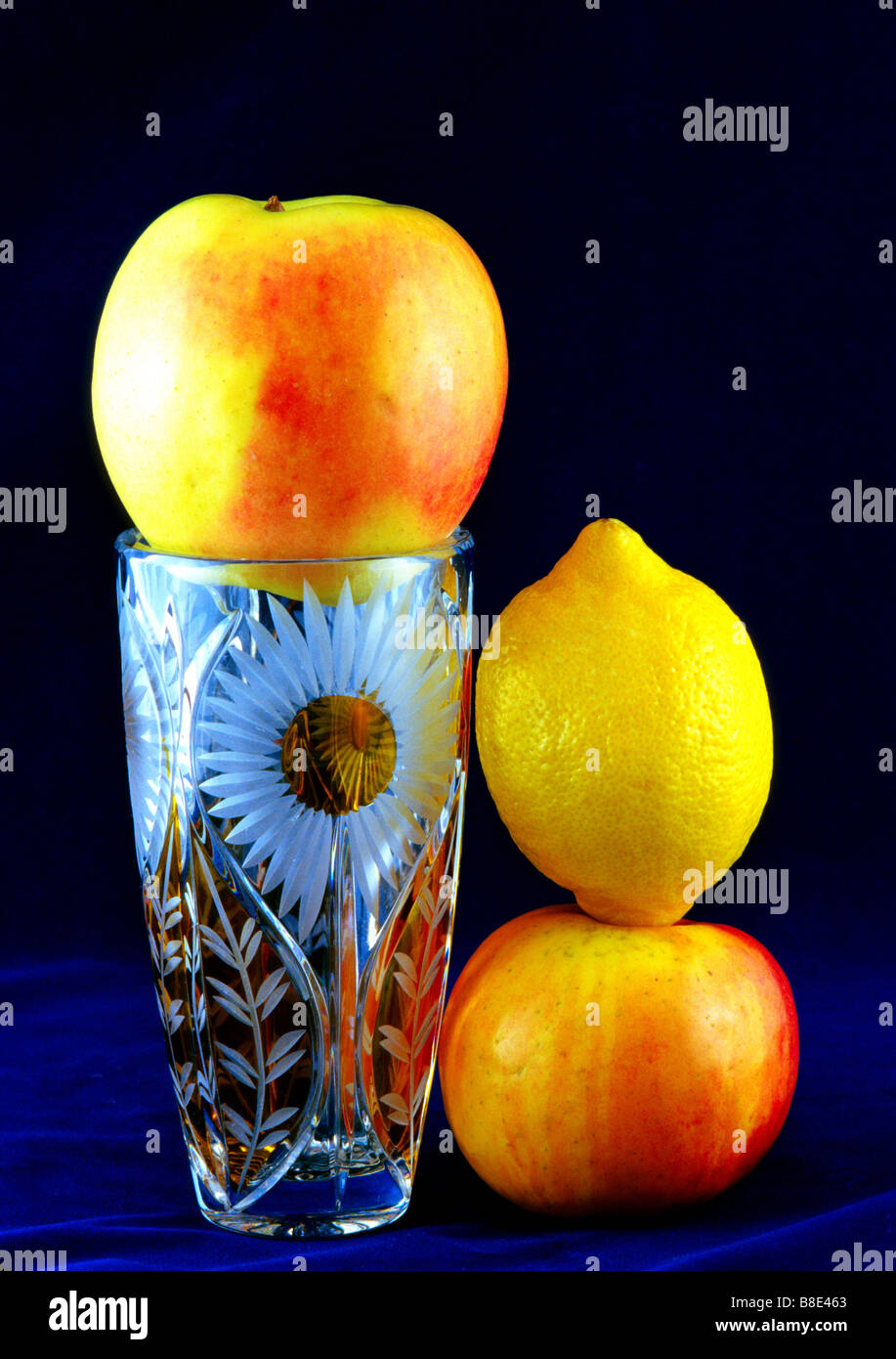 Tre frutti e vaso, cristallo rosso giallo flora botanica botanico frutta cibo ancora in vita composizione orizzontale Foto Stock