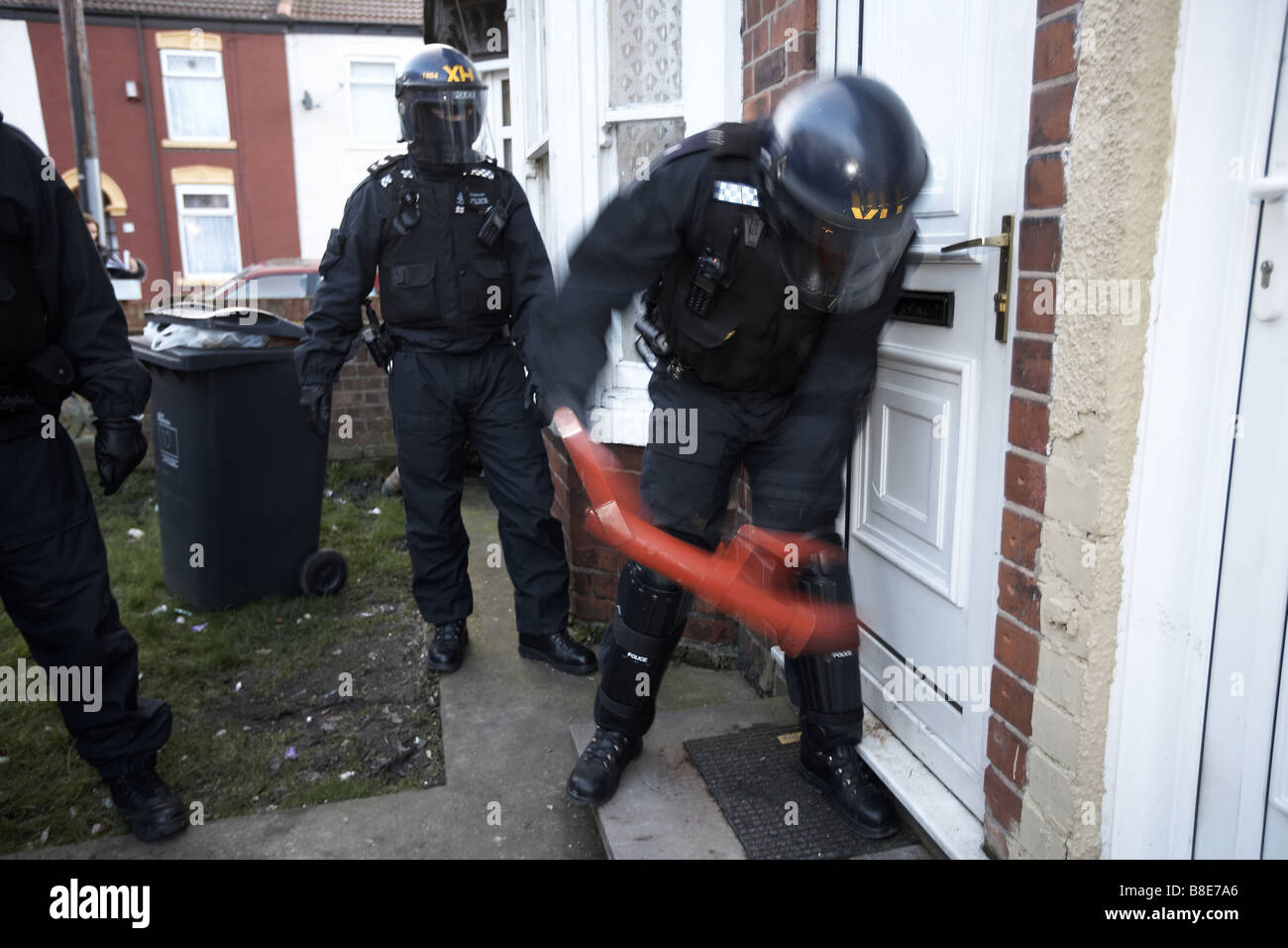 Ufficiali dal quartiere Bransholme Policing Team utilizzano un ariete per immettere una proprietà per la ricerca di farmaci, Hull, Regno Unito Foto Stock