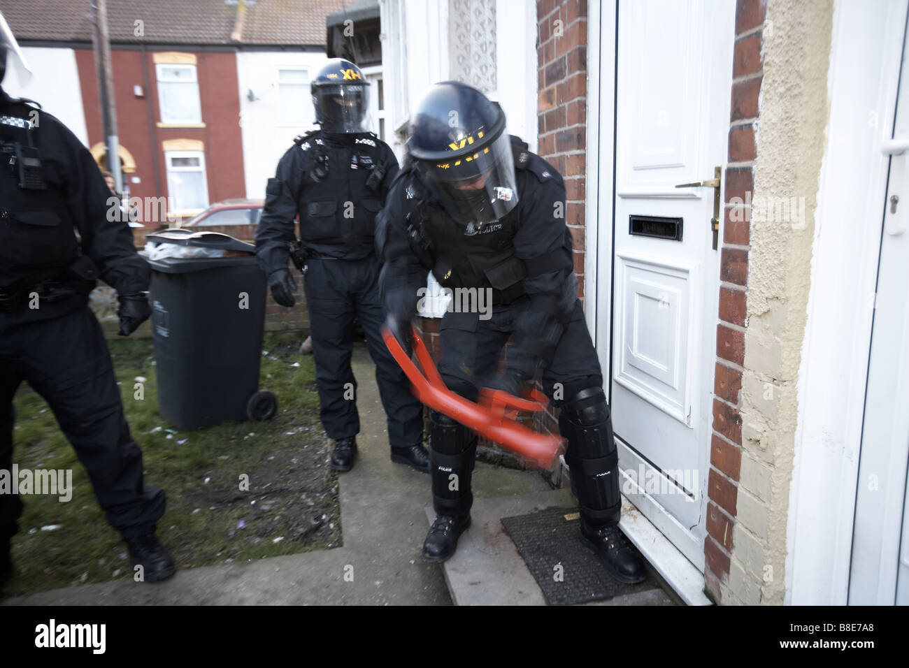 Ufficiali dal quartiere Bransholme Policing Team utilizzano un ariete per immettere una proprietà per la ricerca di farmaci, Hull, Regno Unito Foto Stock