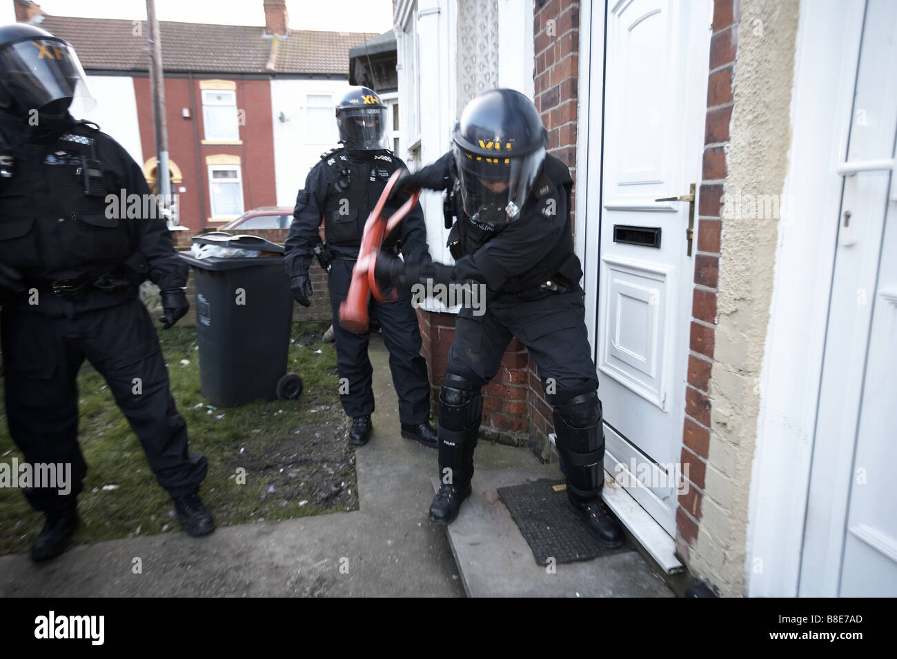 Ufficiali dal quartiere Bransholme Policing Team utilizzano un ariete per immettere una proprietà per la ricerca di farmaci, Hull, Regno Unito Foto Stock